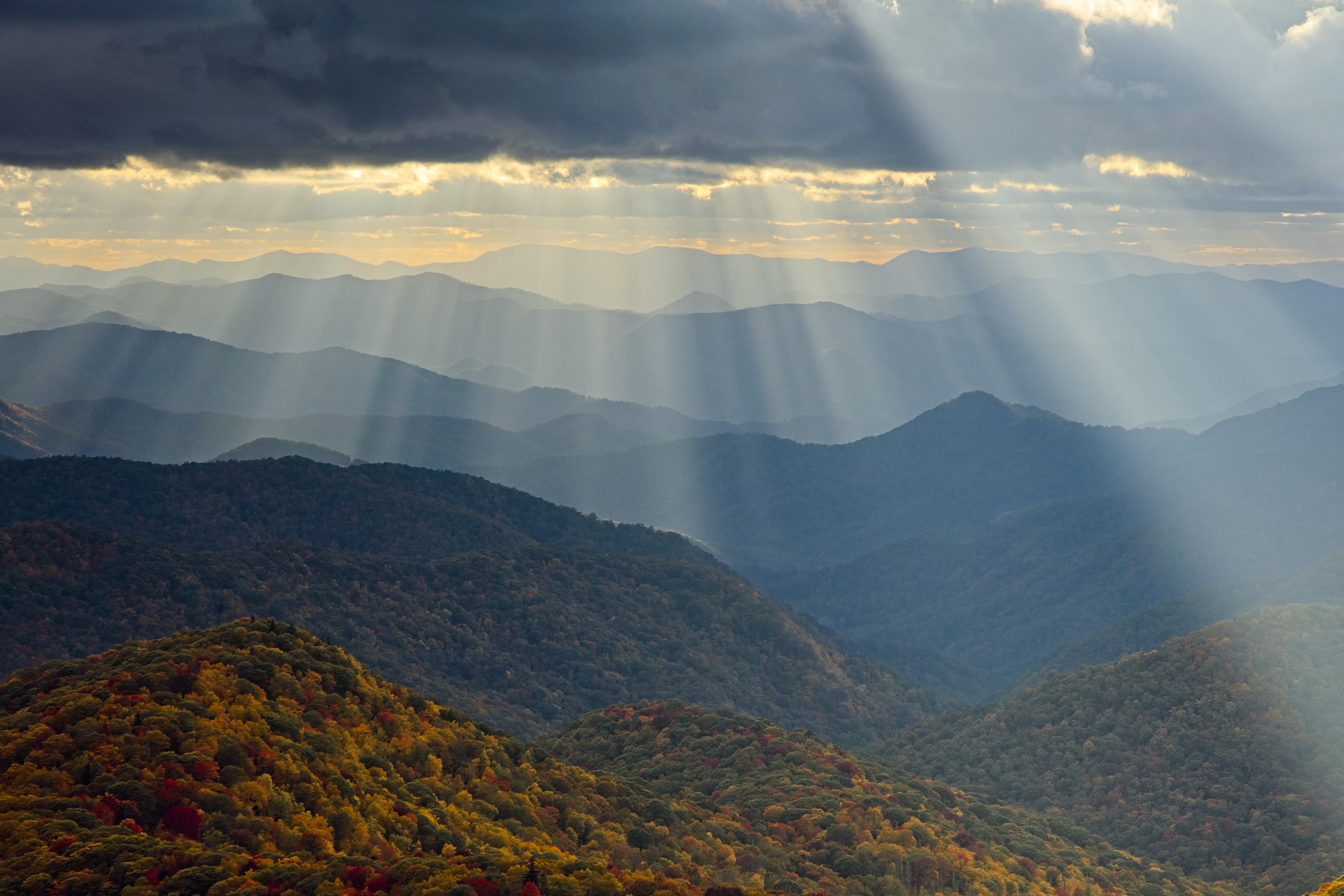 Golden god rays raking across autumn Blue Ridge summits at sunset